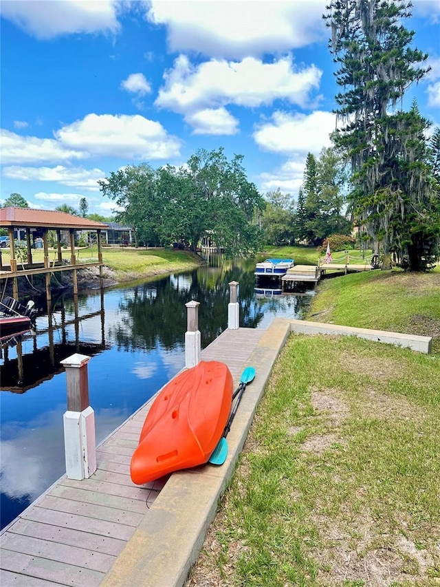 dock area with a water view and a lawn