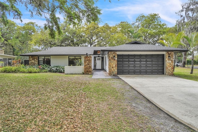 view of front facade featuring stone siding, a garage, driveway, and a front yard
