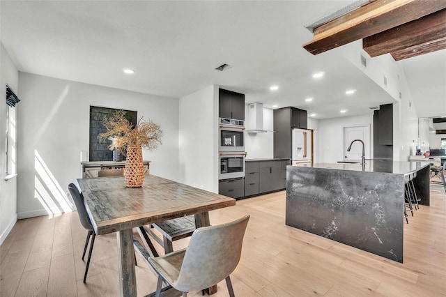 dining space with light wood-style flooring, recessed lighting, and baseboards