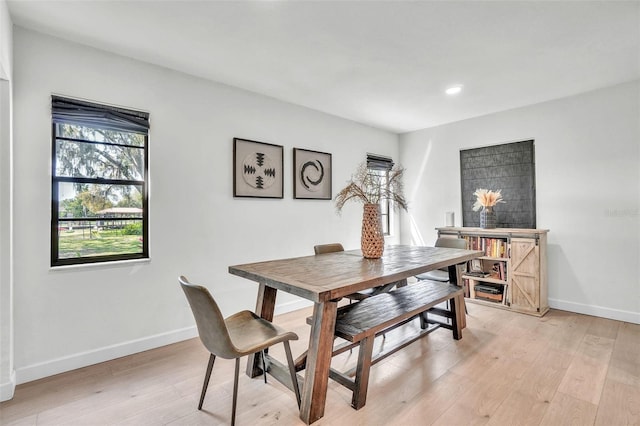 dining room with baseboards, light wood finished floors, and recessed lighting