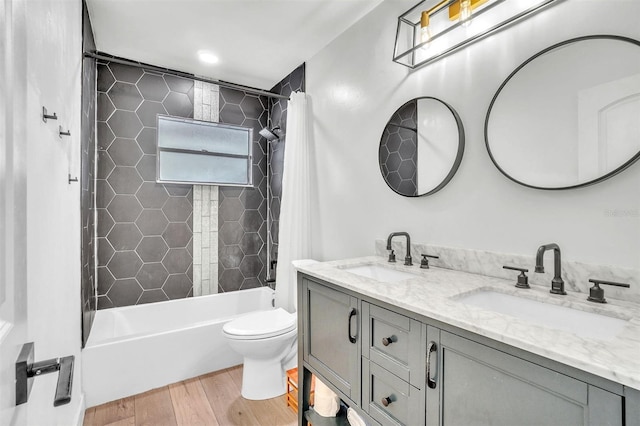 bathroom with wood finished floors, shower / bath combo, toilet, and double vanity