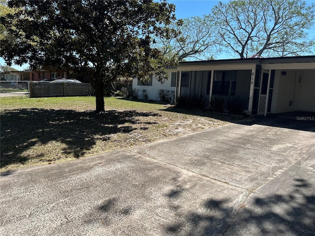 exterior space with driveway, fence, and a yard