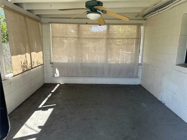 unfurnished sunroom featuring a ceiling fan