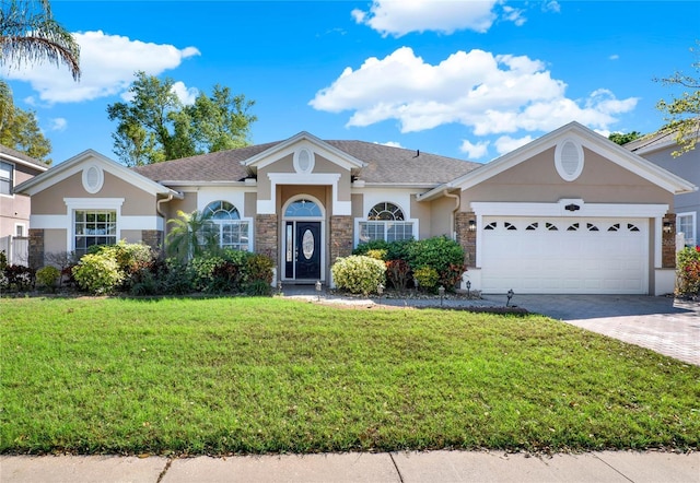 ranch-style house featuring a garage, a front lawn, decorative driveway, and stucco siding