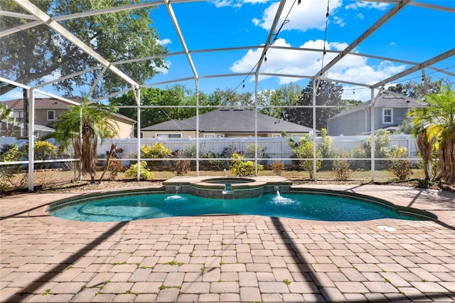 view of swimming pool featuring a lanai, a pool with connected hot tub, fence, and a patio