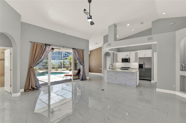 unfurnished living room featuring marble finish floor, baseboards, a sink, and recessed lighting