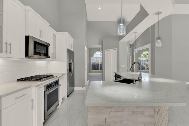 kitchen featuring a large island, glass insert cabinets, appliances with stainless steel finishes, marble finish floor, and a sink