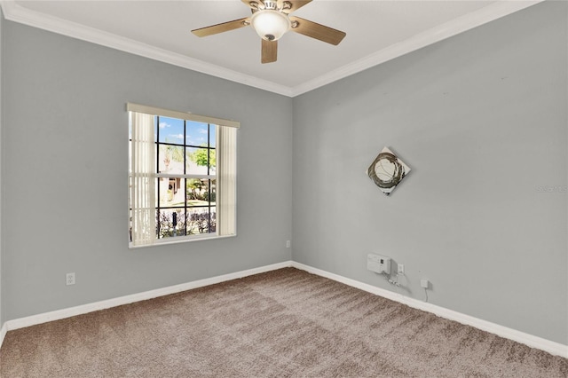 carpeted empty room with ornamental molding, a ceiling fan, and baseboards