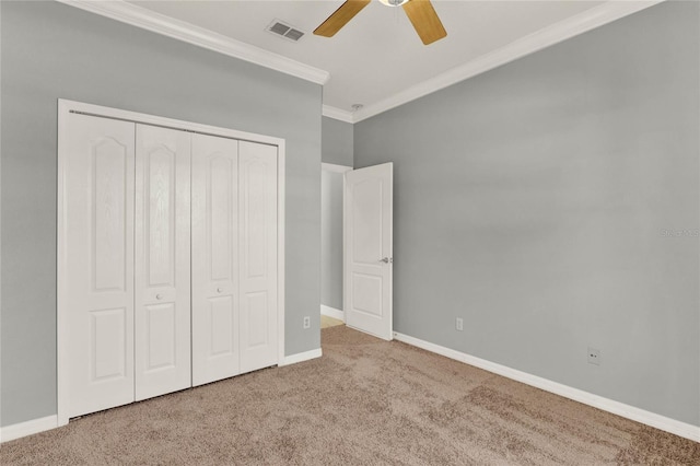 unfurnished bedroom featuring a closet, carpet, visible vents, and crown molding