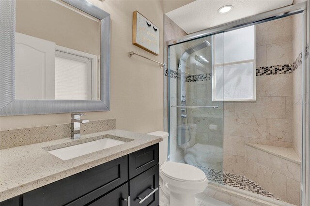 full bath with a stall shower, vanity, and toilet