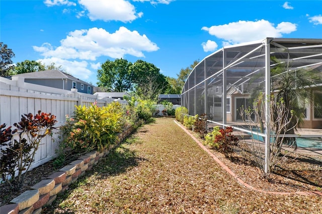 view of yard with a fenced backyard, a fenced in pool, and a lanai