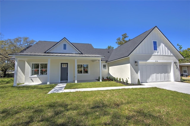 modern inspired farmhouse featuring a standing seam roof, metal roof, a garage, driveway, and a front lawn