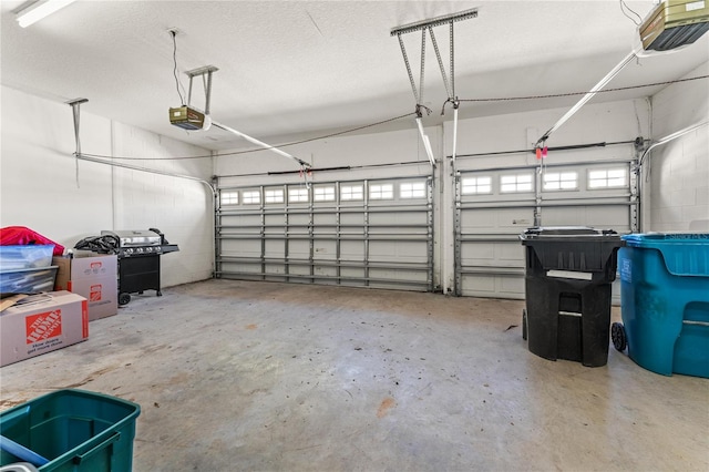 garage with a garage door opener and concrete block wall