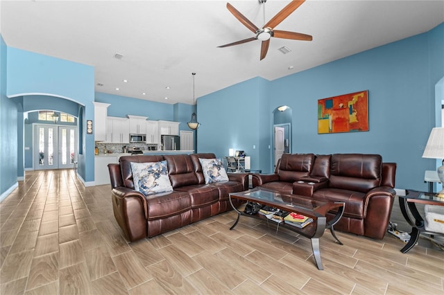 living area featuring visible vents, arched walkways, french doors, ceiling fan, and wood finish floors