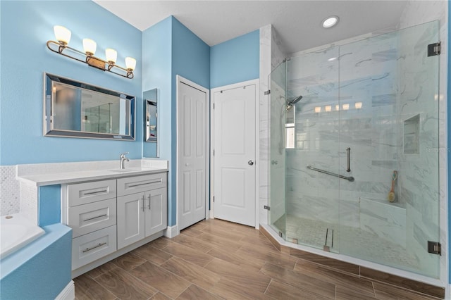 full bath with wood tiled floor, a shower stall, vanity, and a bath