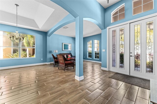 6854 Remington View Ct, Orlando, FL 32829 - entrance foyer with baseboards, arched walkways, an inviting chandelier, and wood tiled floor