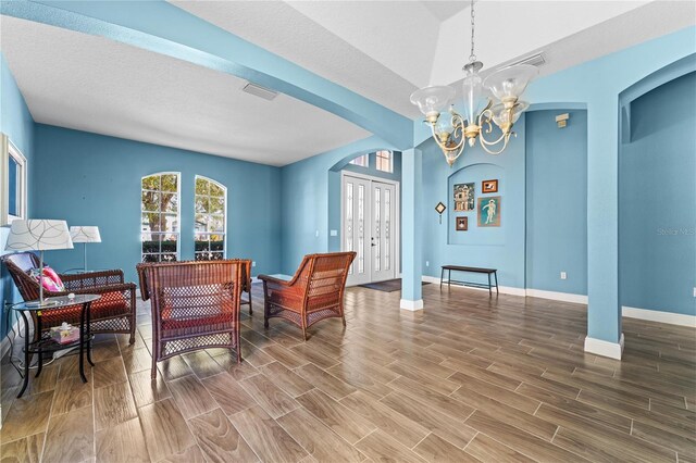 6854 Remington View Ct, Orlando, FL 32829 - sitting room with visible vents, wood finish floors, baseboards, an inviting chandelier, and arched walkways