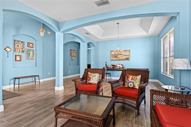 6854 Remington View Ct, Orlando, FL 32829 - sitting room with visible vents, arched walkways, a chandelier, and wood tiled floor