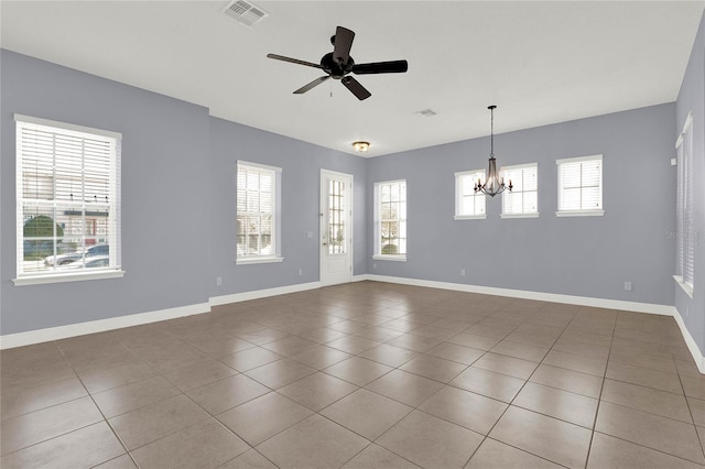 tiled spare room with ceiling fan with notable chandelier, baseboards, and visible vents