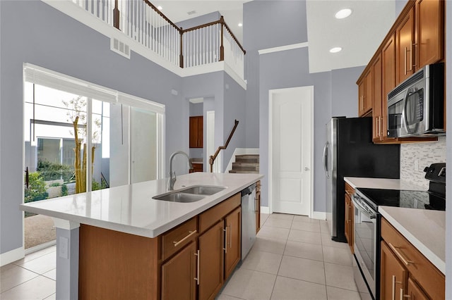 kitchen with a sink, light countertops, brown cabinets, and stainless steel appliances