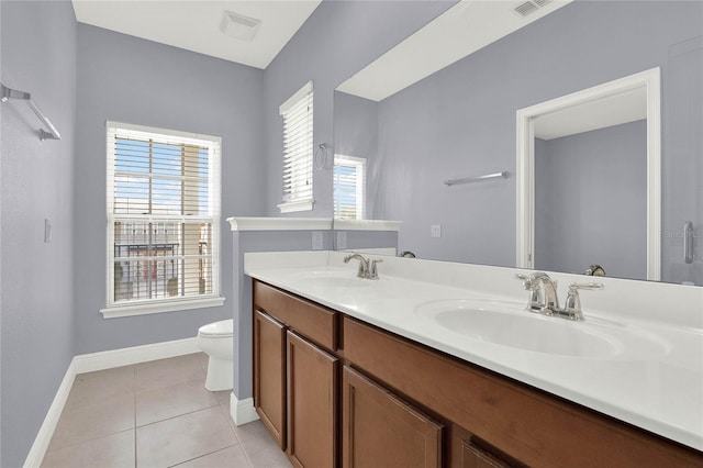 bathroom with tile patterned flooring, toilet, baseboards, and a sink