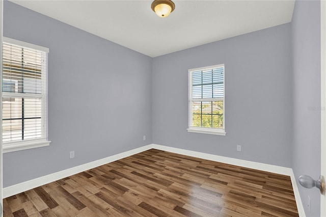 empty room featuring wood finished floors and baseboards