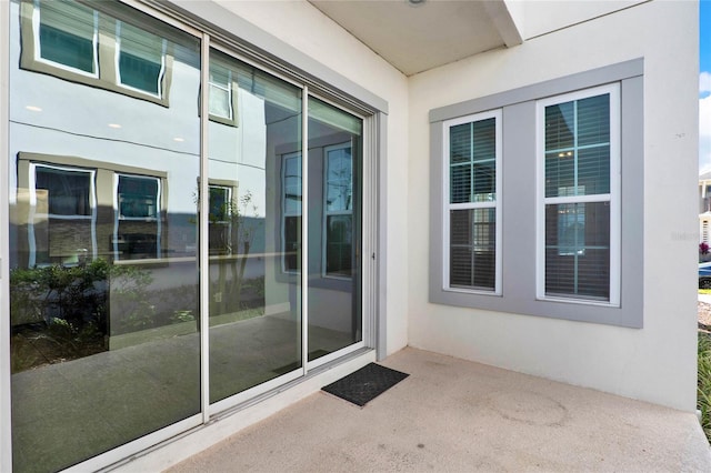 view of exterior entry featuring stucco siding