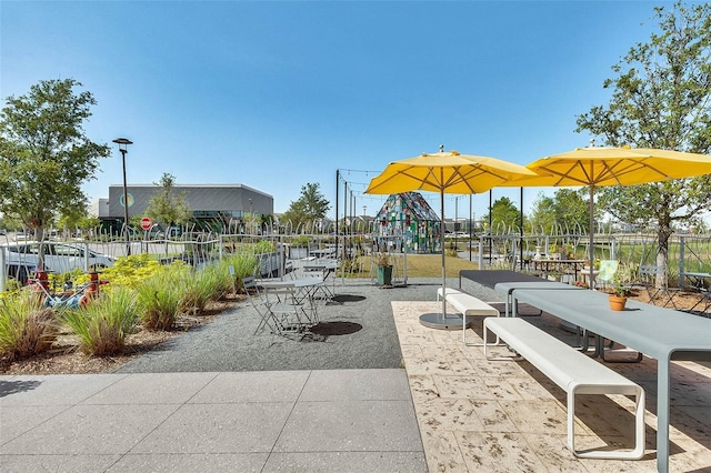 surrounding community with playground community, a patio, and fence