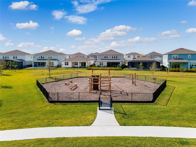 exterior space with a residential view, a lawn, and fence