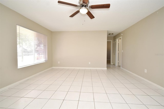 spare room with ceiling fan, light tile patterned floors, and baseboards