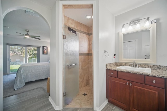 ensuite bathroom featuring visible vents, ceiling fan, a shower stall, ensuite bath, and vanity