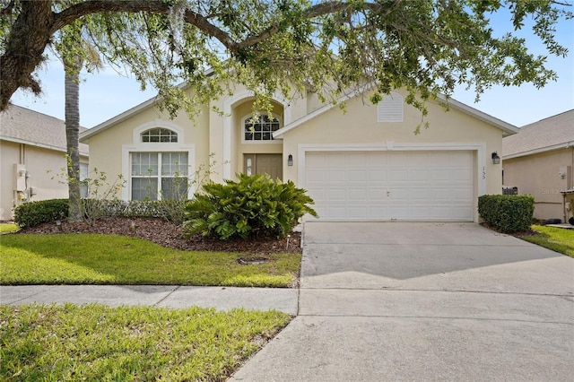 view of front of property featuring concrete driveway, an attached garage, a front yard, and stucco siding