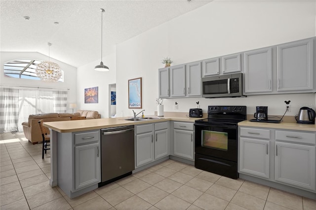 kitchen with gray cabinets, appliances with stainless steel finishes, a peninsula, light tile patterned flooring, and a sink