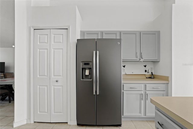 kitchen featuring light countertops, gray cabinets, stainless steel refrigerator with ice dispenser, and light tile patterned floors