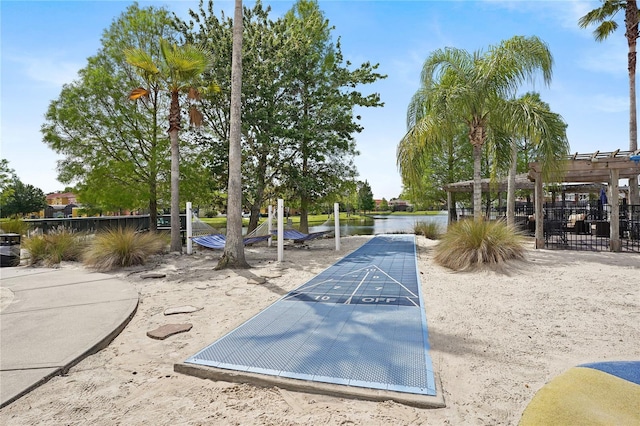 view of community featuring shuffleboard, a pergola, and fence