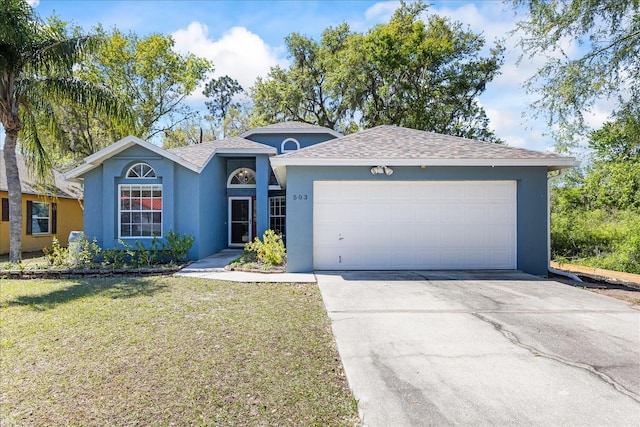 ranch-style home with a garage, driveway, a front yard, and stucco siding