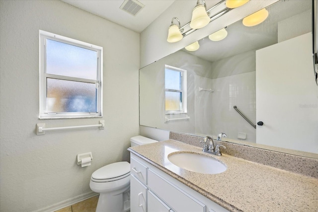 bathroom featuring visible vents, toilet, vanity, baseboards, and walk in shower