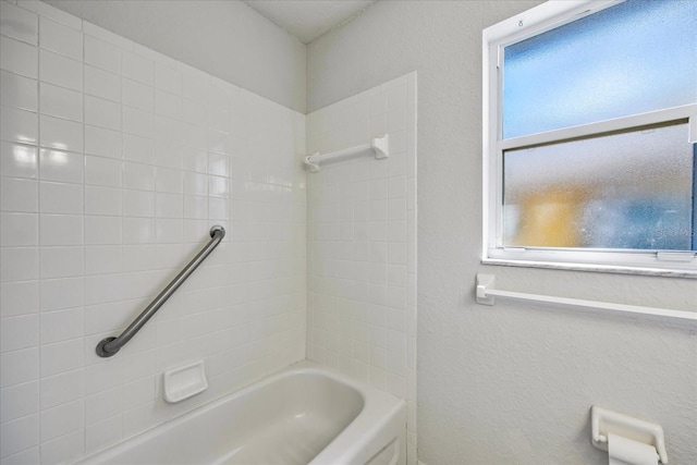 full bathroom with shower / washtub combination and a textured wall