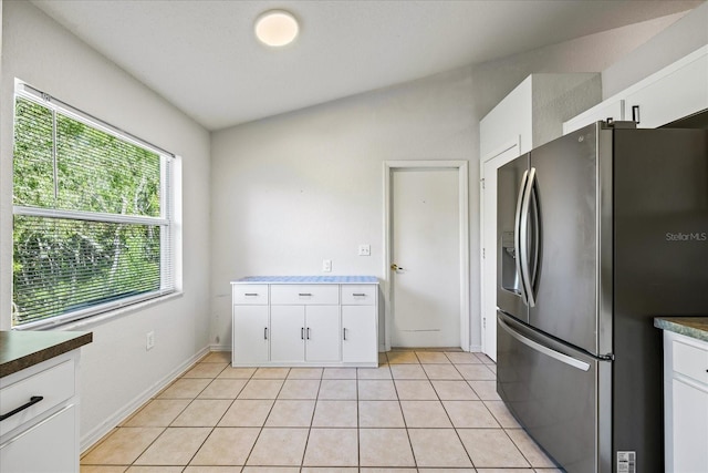 kitchen with baseboards, light tile patterned flooring, white cabinets, and stainless steel fridge with ice dispenser