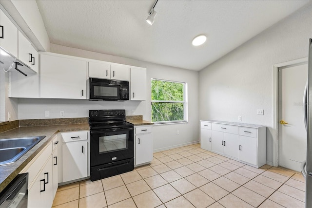 kitchen featuring light tile patterned floors, dark countertops, white cabinetry, a sink, and black appliances