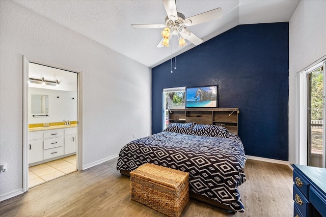 bedroom with lofted ceiling, a sink, and wood finished floors