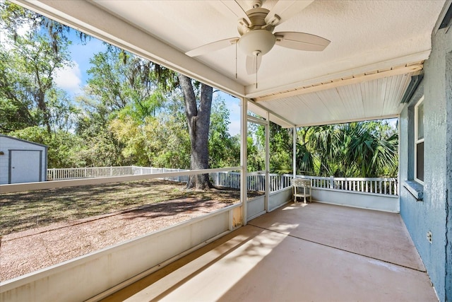 unfurnished sunroom with ceiling fan