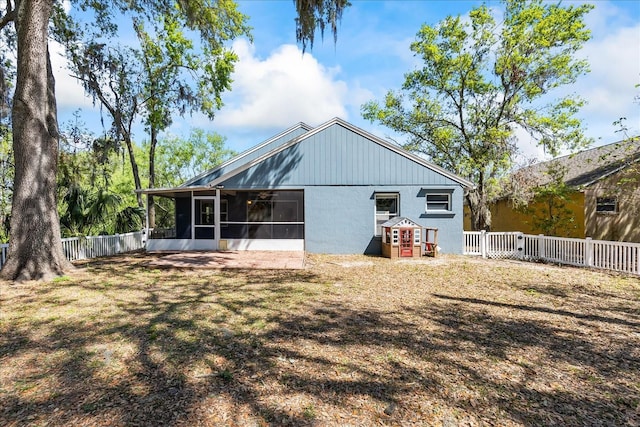 back of house with fence and a sunroom