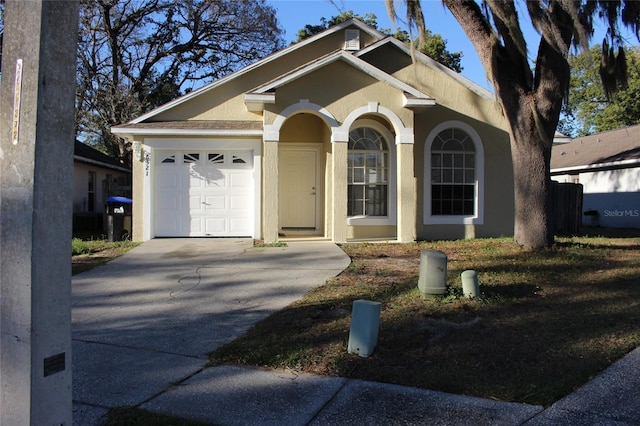 ranch-style house with a garage, concrete driveway, and stucco siding