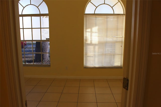 empty room with baseboards and tile patterned floors