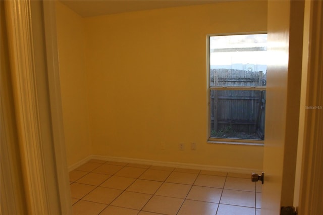 unfurnished room with baseboards and light tile patterned floors