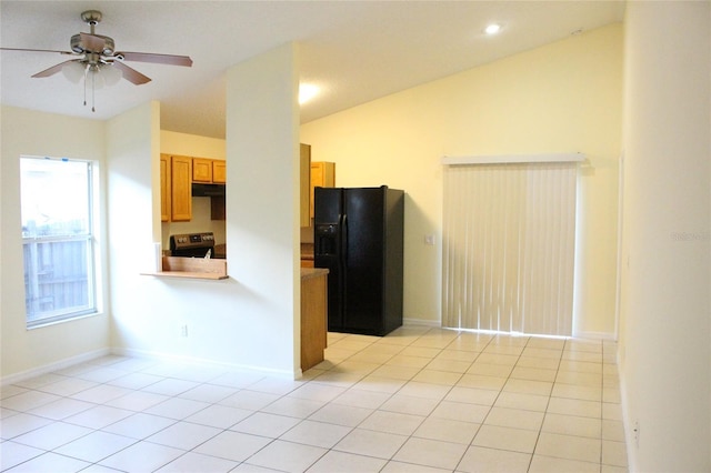 kitchen with lofted ceiling, black fridge, light tile patterned flooring, and stainless steel electric stove