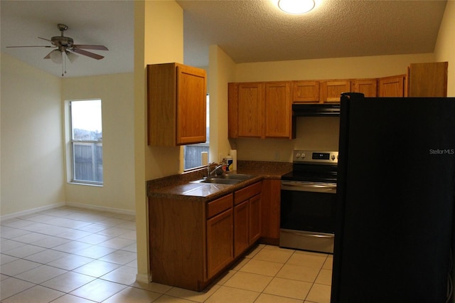 kitchen with electric stove, dark countertops, freestanding refrigerator, extractor fan, and a sink