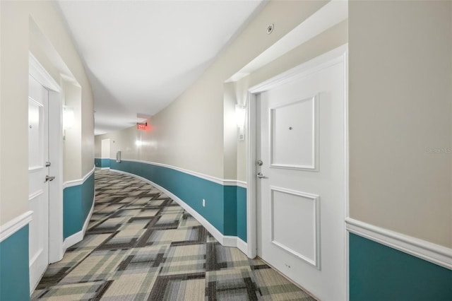 hallway with carpet flooring and baseboards