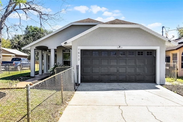 view of front of house featuring an attached garage, fence, driveway, and stucco siding